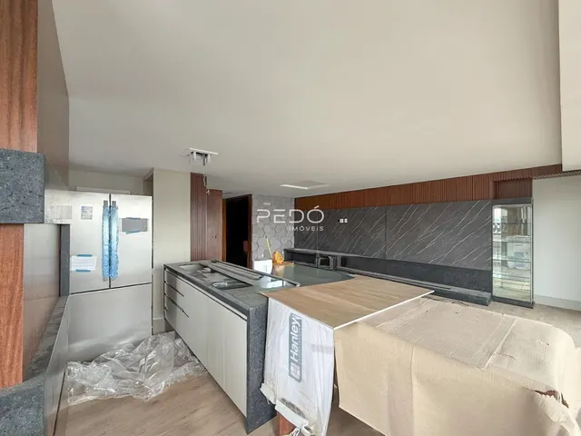 Vista interna de uma cozinha com armários e bancada em obra.