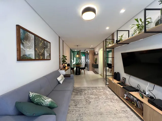 Sala de estar moderna com sofá cinza e decoração de madeira.