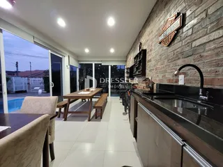 Ambiente interno de uma sala de estar com vista para a área externa e piscina.
