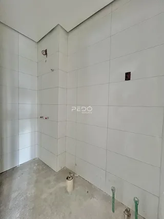 Foto de uma parede interna com revestimento cerâmico branco.