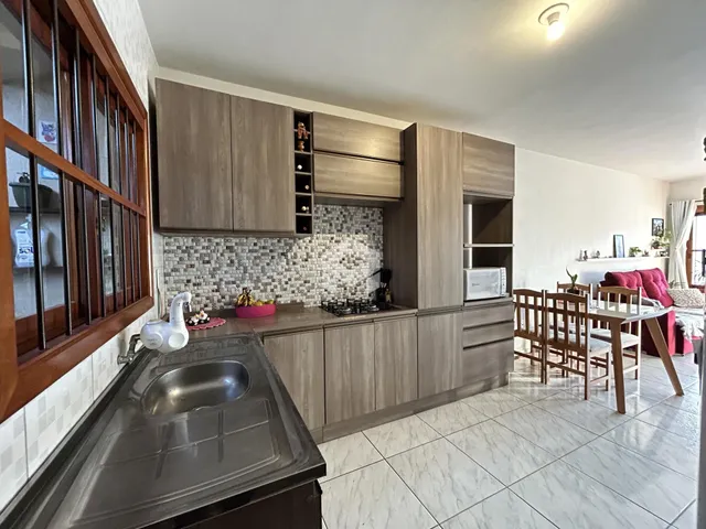 Cozinha com armários de madeira e revestimento de azulejos brancos.