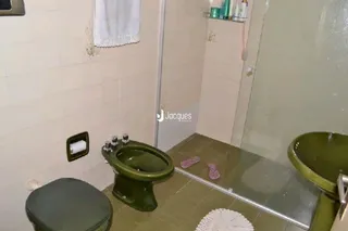Foto do interior de um banheiro com azulejos brancos.