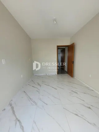 Vista de um corredor interno com piso de mármore branco.