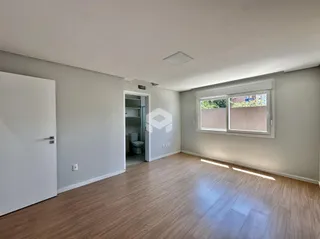 Sala de estar com piso de madeira clara e parede cinza.