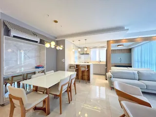 Sala de jantar iluminada com mesa e cadeiras em um apartamento em Lajeado.