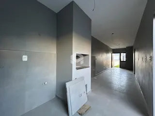 Corredor interno de um imóvel em Lajeado, Brasil, com paredes cinzas e piso de concreto.