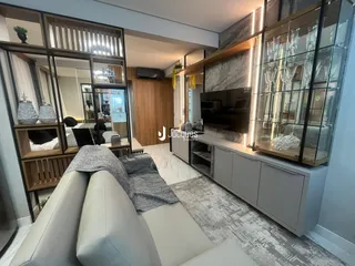 Sala de estar com sofá e painel de madeira em um imóvel.