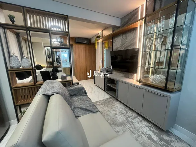 Sala de estar com sofá e painel de madeira em um imóvel.