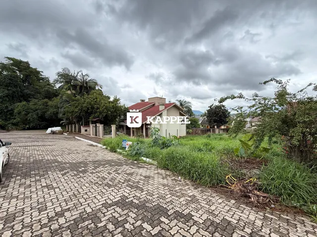 Fachada de uma residência em Lajeado, Brasil, com paisagismo e acesso por estrada de paralelepípedos.