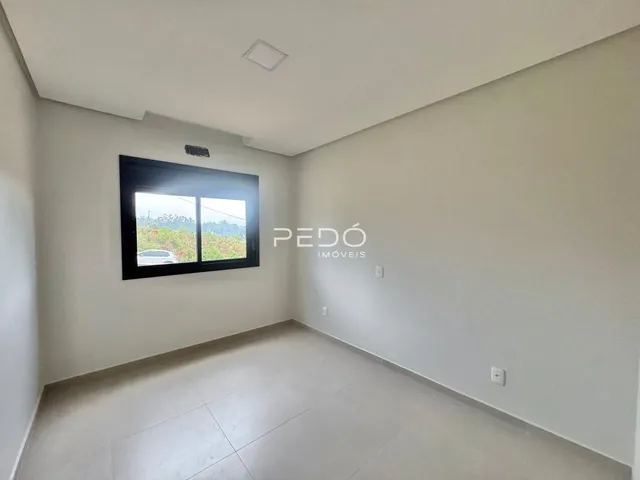 Sala de estar com piso claro e janela em um imóvel no Brasil.