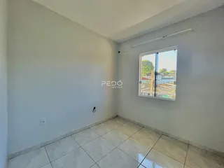 Ambiente interno de uma sala com piso de cerâmica e janela.