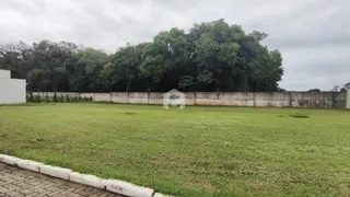 Vista externa de um terreno com gramado e muro de contenção.