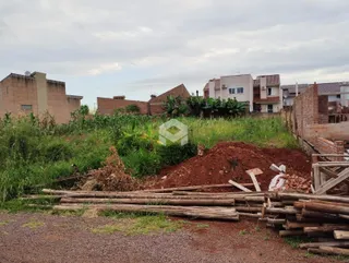 Vista externa de uma propriedade com vegetação alta e terra no primeiro plano.