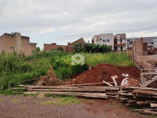 Vista externa de uma propriedade com vegetação alta e terra no primeiro plano.