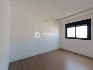 Vista interna de uma sala com piso de madeira clara.