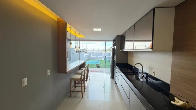 Vista de uma sala de estar moderna com acesso a um pátio com piscina.