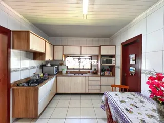 Cozinha com armários de madeira e piso de cerâmica.