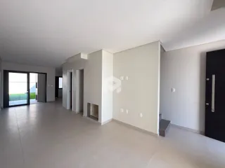 Interior de uma sala ampla com piso de concreto e paredes brancas.