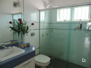Foto de um banheiro com box de vidro e pia.