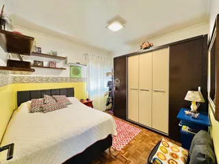 Quarto com armários embutidos e piso de madeira.