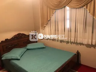 Um quarto com cama e cortinas claras.