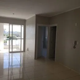 Hall de entrada com piso de porcelanato reflexivo e portas de vidro.