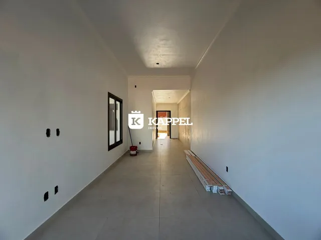 Corredor interno de uma residência com paredes brancas e piso claro.