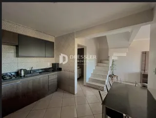 Ambiente interno com cozinha e escadaria em um imóvel.