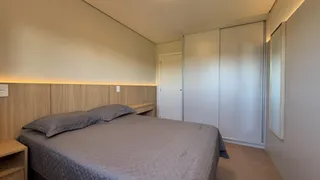 Quarto com cama e armário branco em um ambiente bem iluminado.