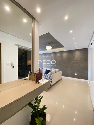 Sala de estar moderna com piso de madeira clara e parede texturizada.