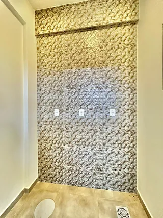 Parede decorada com revestimento texturizado em um banheiro.