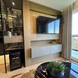 Sala de estar com painel de madeira e televisão montada na parede.