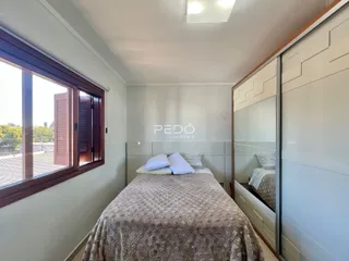 Quarto com janela de madeira e cabeceira de cama.