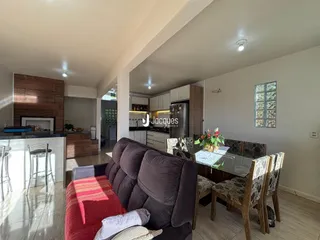 Sala de estar e jantar com sofá e mesa de jantar em um apartamento.