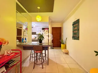 Vista de um ambiente interno com mesa de jantar e parede decorada.