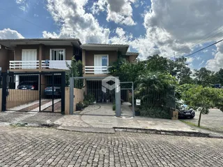 Fachada de uma residência em Lajeado, Brasil, com portão de ferro e cerca.