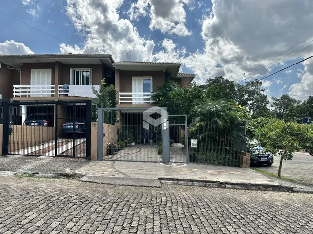 Fachada de uma residência em Lajeado, Brasil, com portão de ferro e cerca.