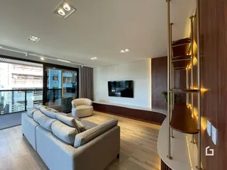 Sala de estar moderna com piso de madeira e vista para o exterior.