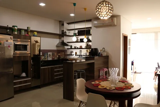 Interior de uma sala de estar com cozinha em um imóvel no Brasil.