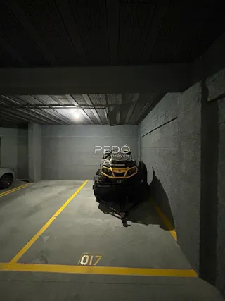 Imagem de uma garagem com piso de concreto e um veículo estacionado.