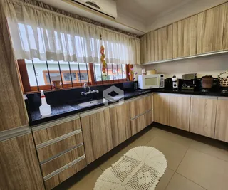 Vista da cozinha com armários e bancadas de madeira.