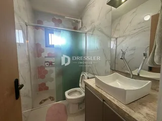 Foto de um banheiro com revestimento em mármore e box de vidro.