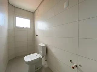 Foto de um banheiro com paredes brancas e piso claro.