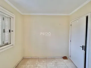 Ambiente interno de uma sala com piso de cerâmica e janela.