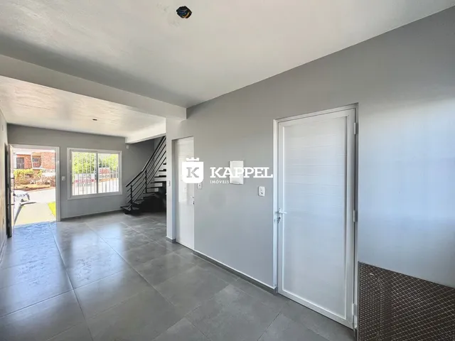 Hall de entrada com piso de cerâmica e porta branca.