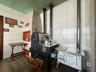 Foto de uma cozinha rústica com fogão a lenha e paredes de tijolo exposto.