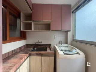 Cozinha com armários rosados e bancada de granito.