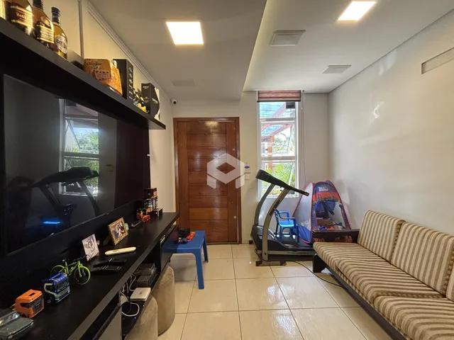 Sala de estar com sofá e televisão em um apartamento.