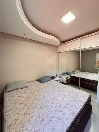 Quarto com cama de casal e roupa de cama branca.