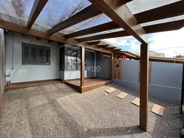 Foto de uma área externa coberta com piso de cascalho e estrutura de madeira.
